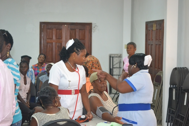 Staff Nurse at the Alexandra Hospital Tovenia Reid conducting pressure checks for seniors on Nevis St. Paul’s Conference Hall on October 12, 2015